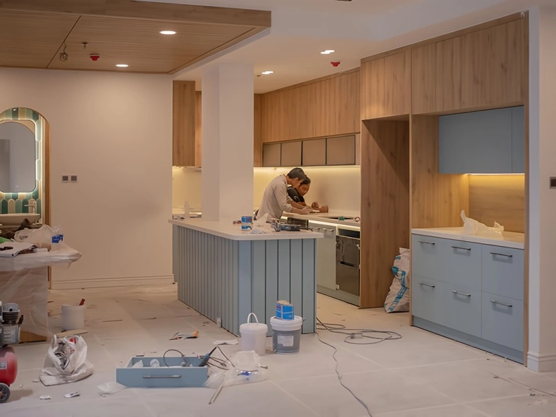 Worker renovating a modern kitchen with tools and materials