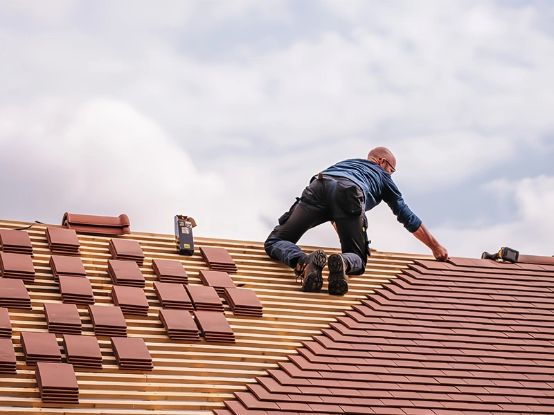 Roofer installing shingles on a residential roof